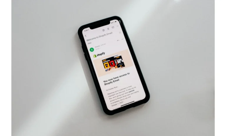 Photo of a smartphone on a white counter with a welcome email from Shopify on the screen.